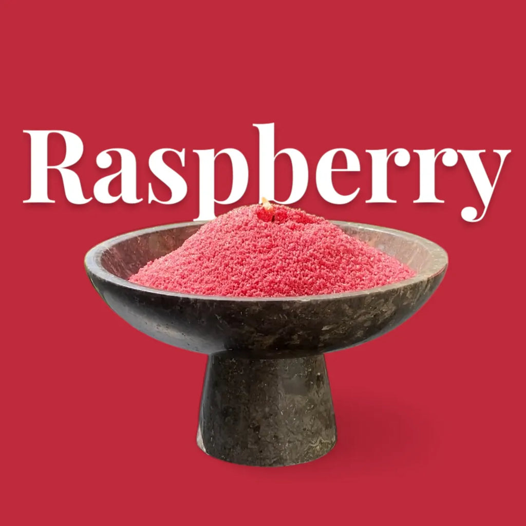 Raspberry colored candle sand in a decorative bowl on a stand